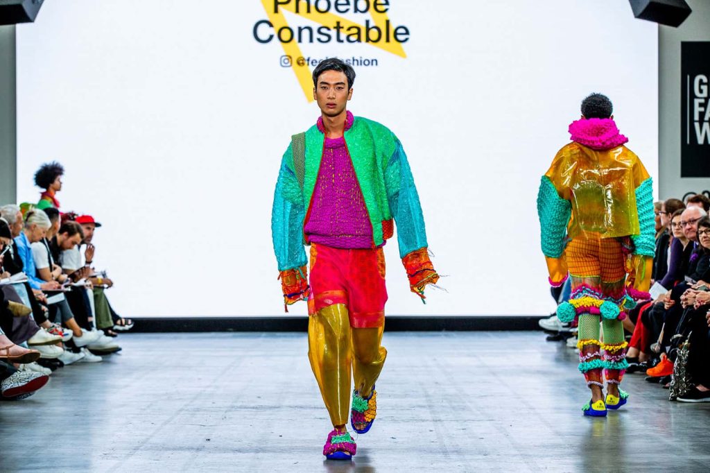 Model wearing eco and sustainable plastic walks down the catwalk at Graduate Fashion Week in colourful clothes by Phoebe Constable