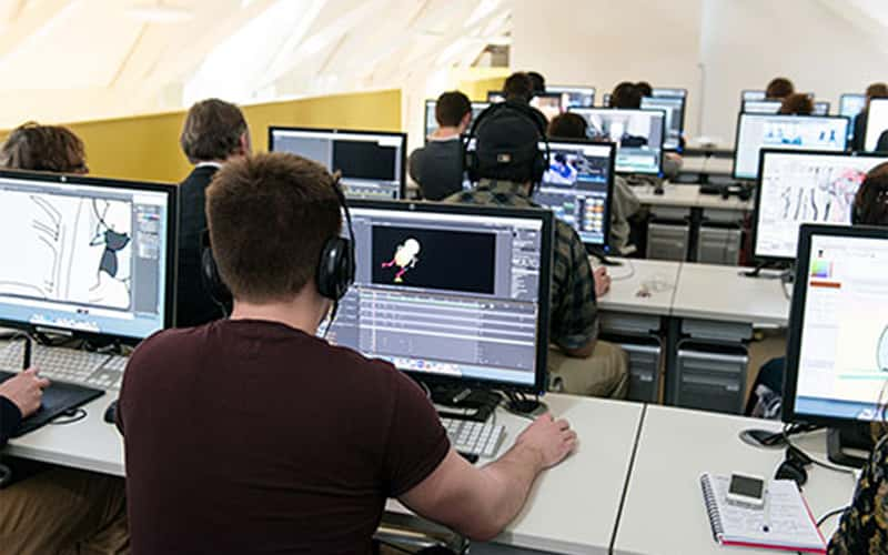 photo shows students at Norwich University of the Arts working on computers in the Media Lab