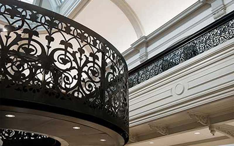 interior photo of boardman house atrium showing staircase with black metal railing and upper level railing and curved walls