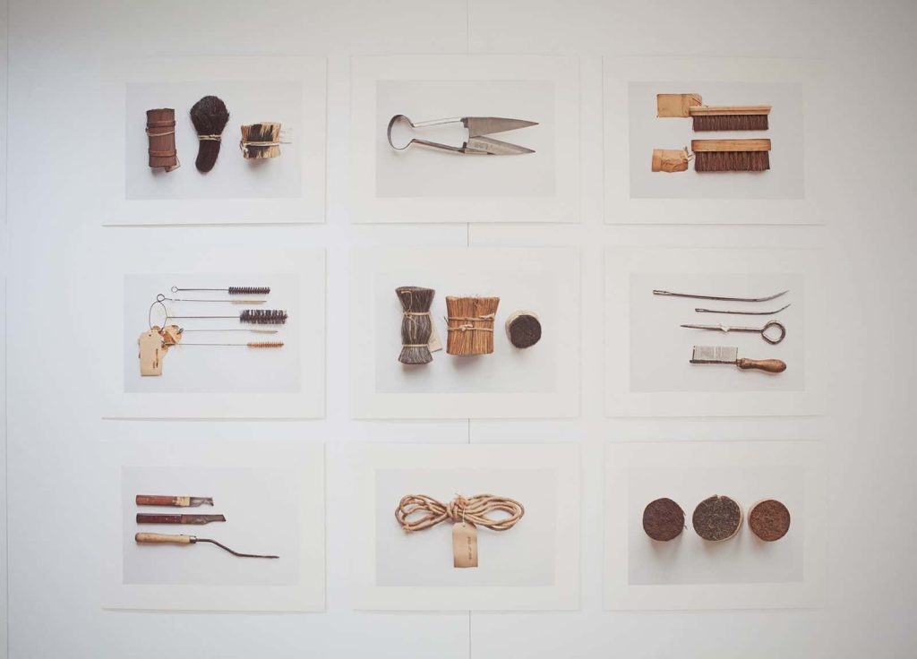 Image of hung photographs which feature found objects inlcuding balls of string and scissors