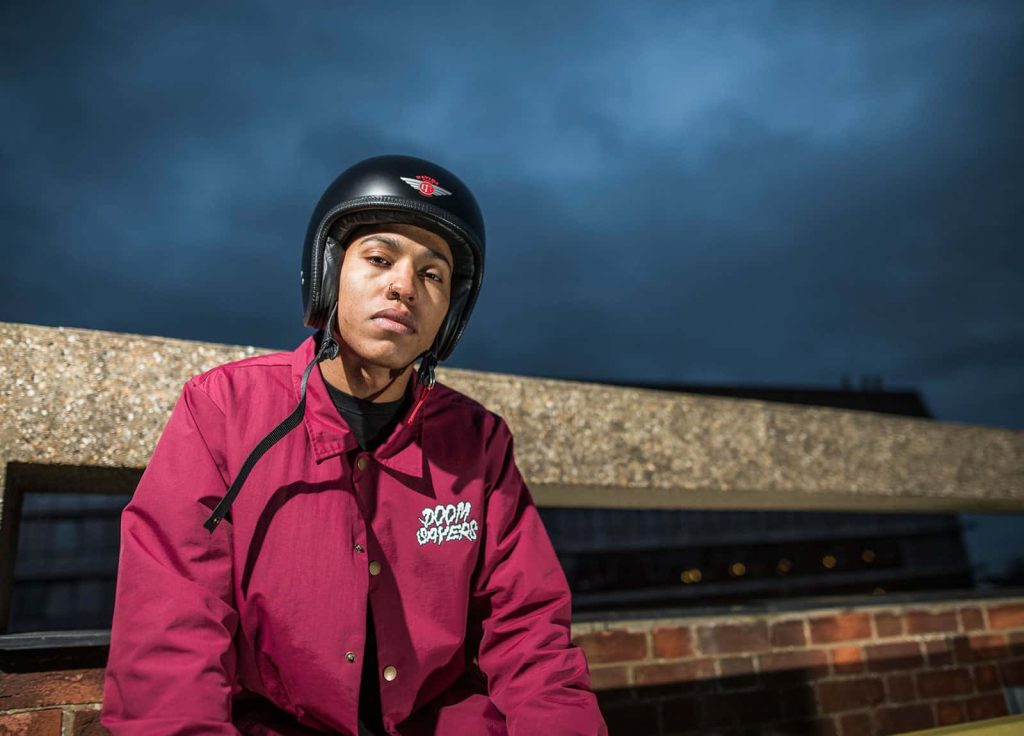 Image of a model wearing a helmet, posing on the top of a concrete building