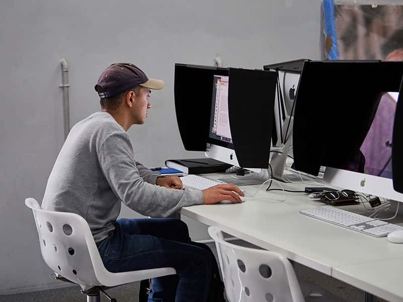 Image of a student working in the digital darkroom working on a computer