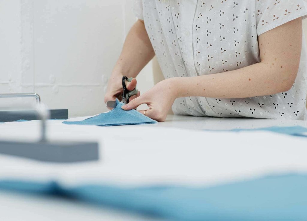 Image of a student cutting materials in one of Norwich University of the Arts's fashion studios