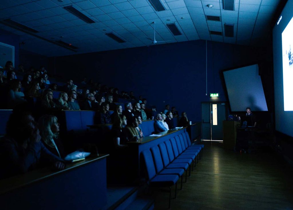 Image of the Norwich University of the Arts lecture Theatre with a seated audience