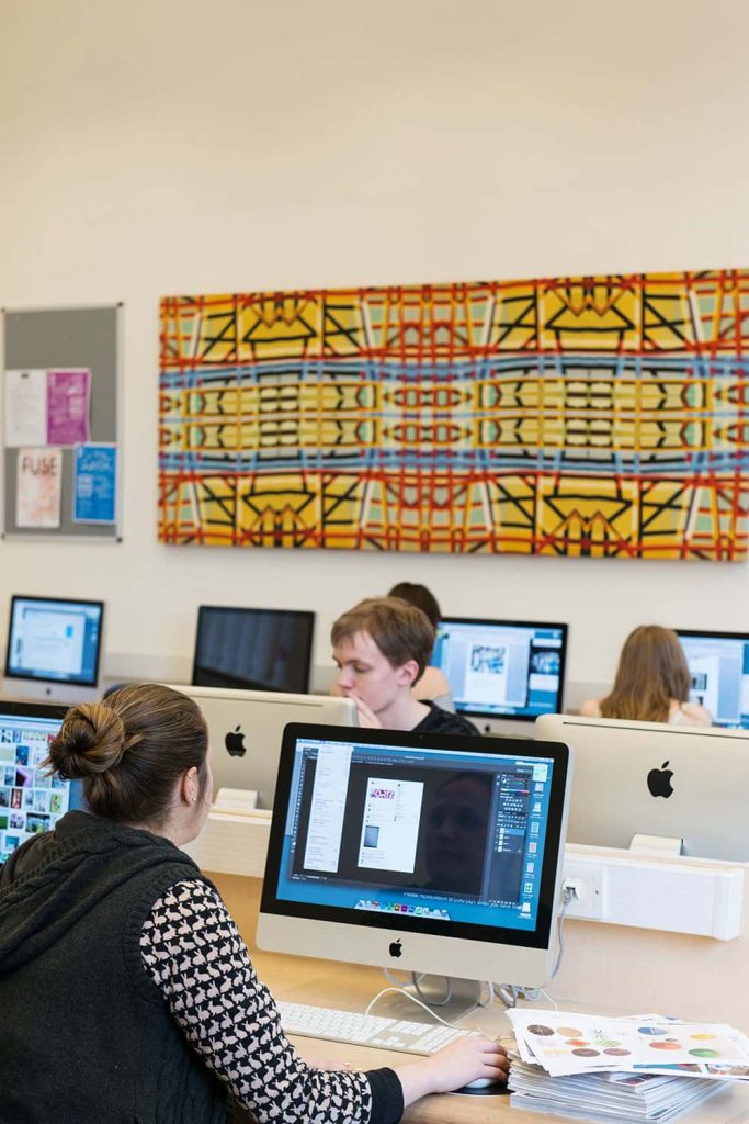 Image of students on computers in a library