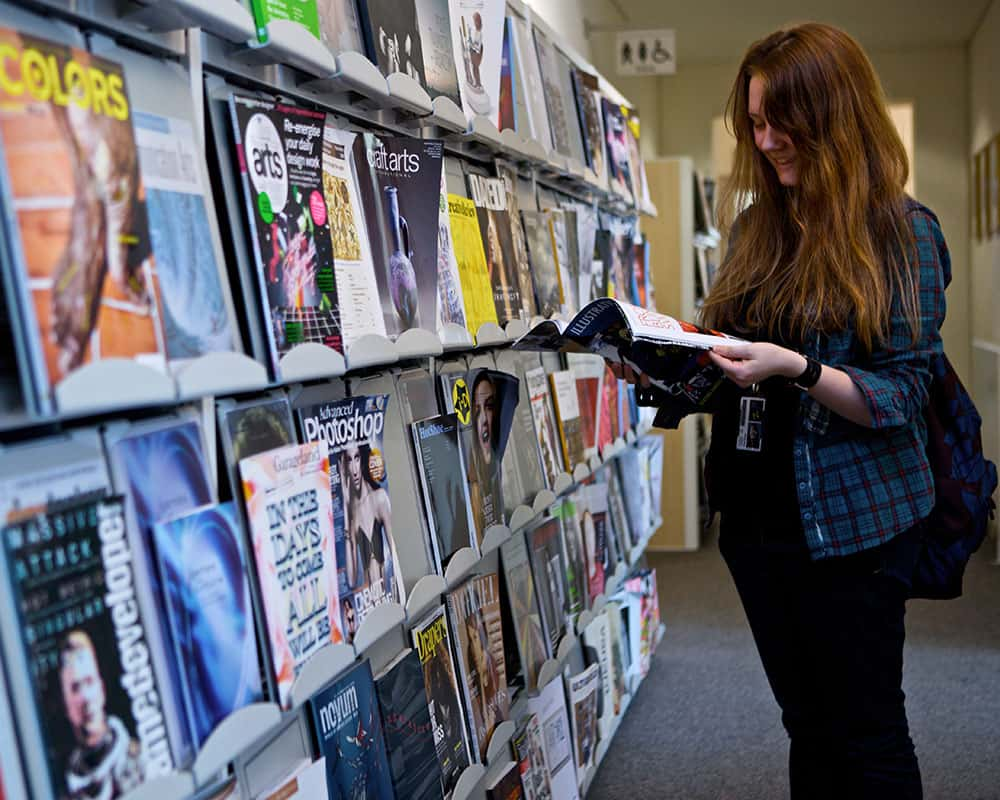 Image of a student looking at items in the Norwich University of the Arts library