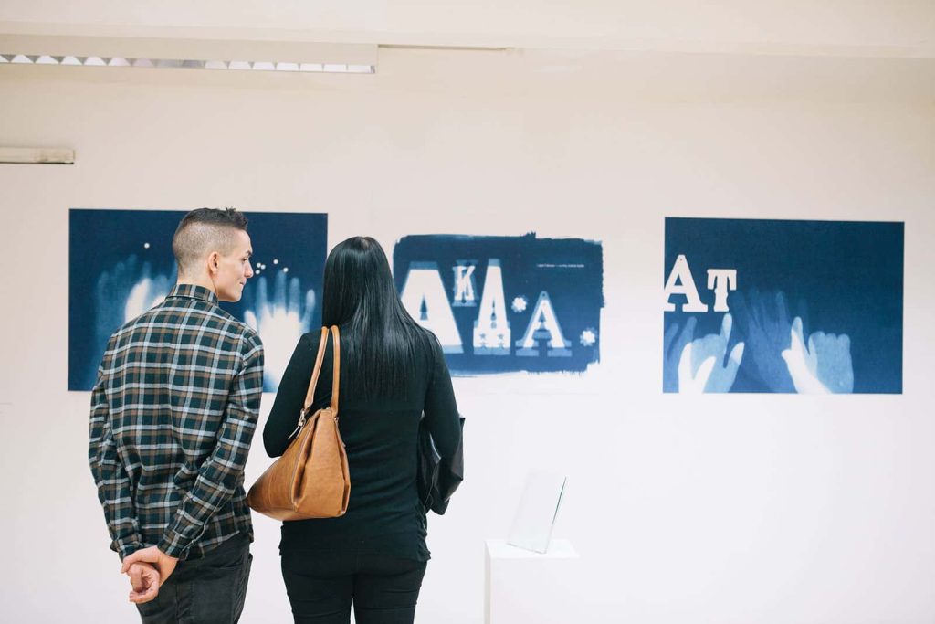 Visitors viewing work in the MA Degree Show