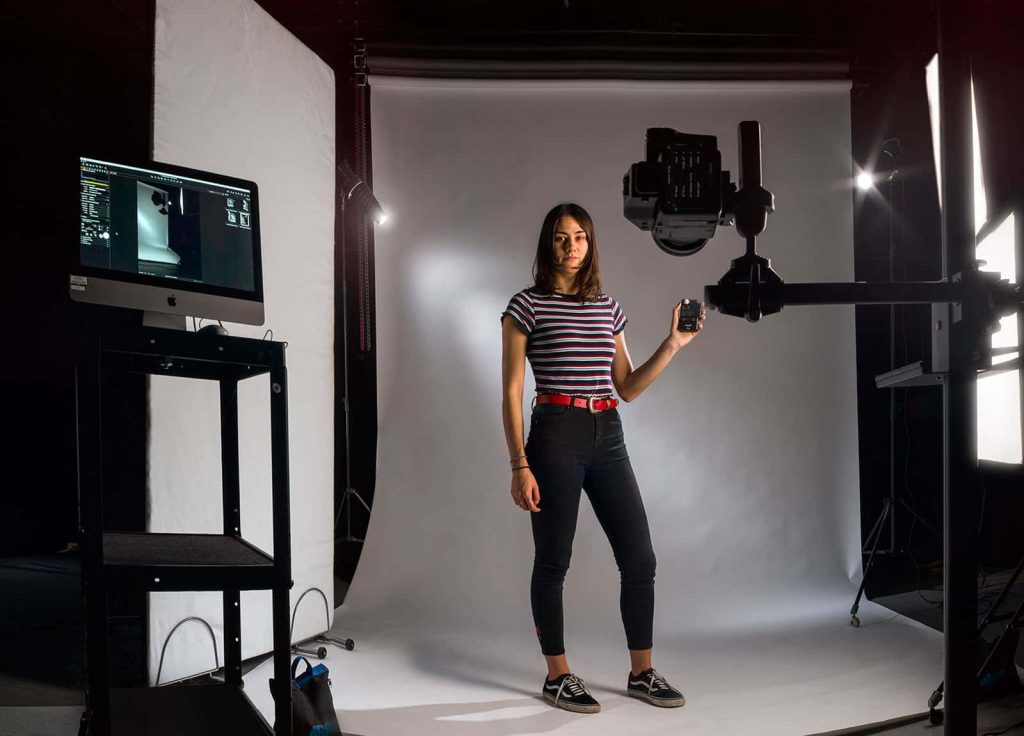 Image of a student posing in a photography studios testing the light