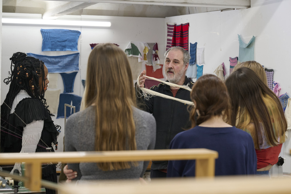 Technician teaching students. They have yarn in their hands