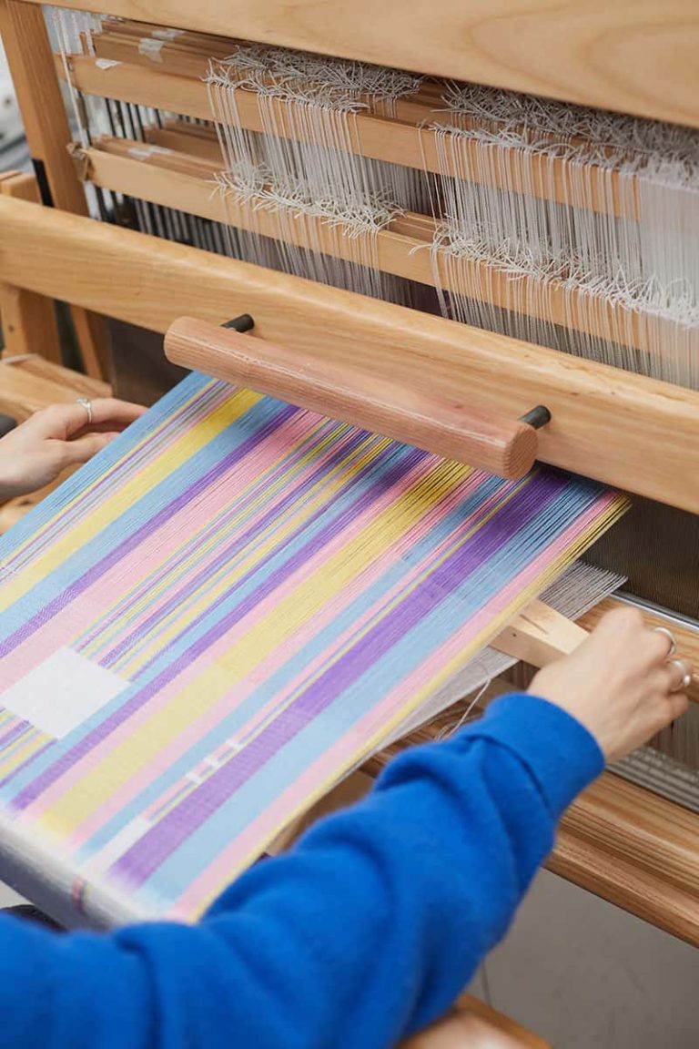 Rebecca Hiscock, BA Textile Design student at Norwich University of the Arts on a loom in the textiles workshop