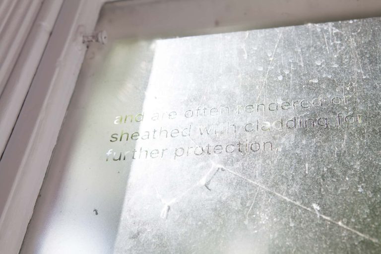 Photograph from BA Degree Show 2017 of a frosted window with clear text