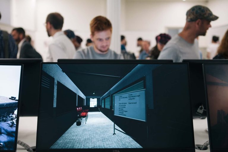 Photograph from BA Degree Show 2017 with close-up screens in the foreground and out of focus people behind