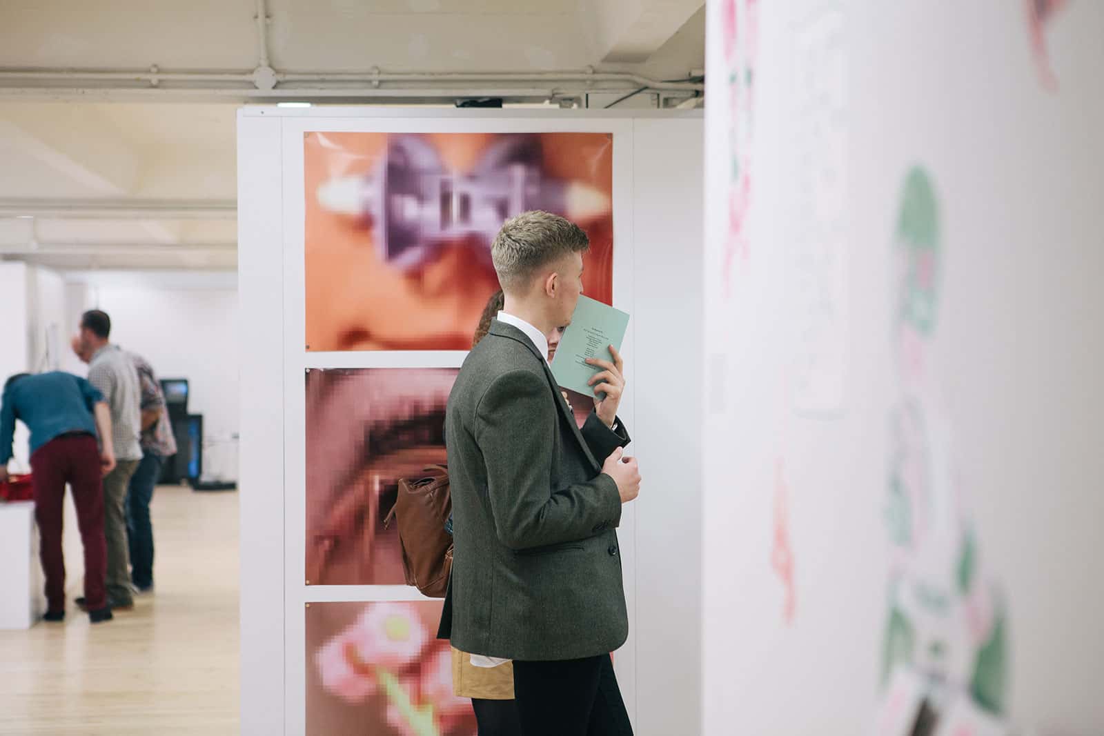 Visitor views colourful Graphic Design work in the Norwich University of the Arts Degree Show
