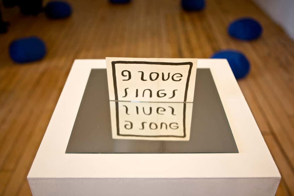 Work by Nicola Simpson, Fine Art Research Student at Norwich University of the Arts stating 'I Love Sings' on plinth