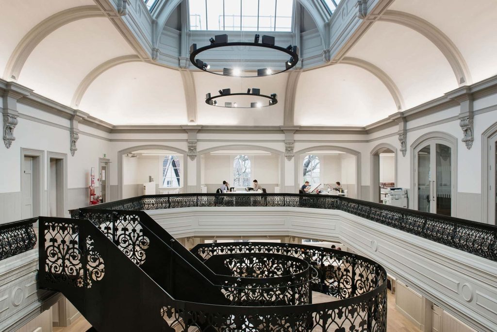 The interior of Boardman House, Norwich showing a staircase and large hanging lights and skylights