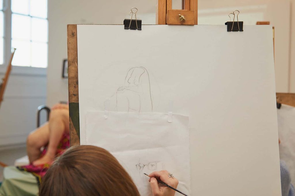 Student draws life model in the Munnings Drawing Studio at Norwich University of the Arts