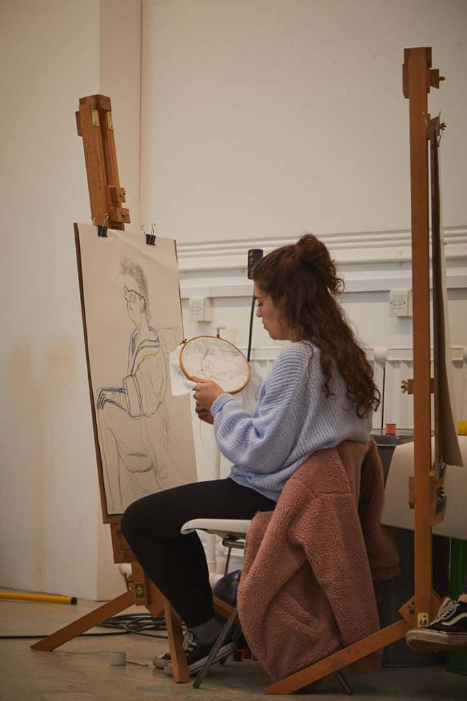 Student works sewing canvas in Munnings Drawing Studio at Norwich University of the Arts