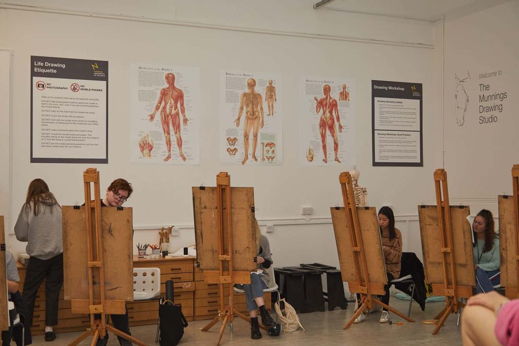 Students sit by easels in Munnings Drawing Studio at Norwich University of the Arts