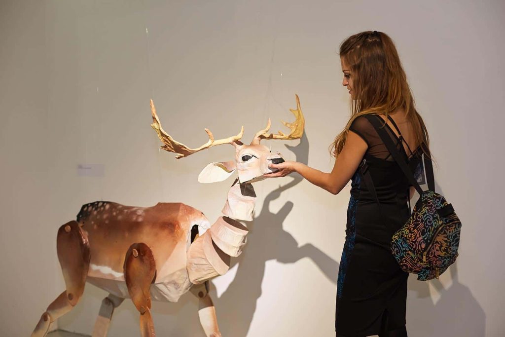 BA Fine Art student stands in front of her work - a deer