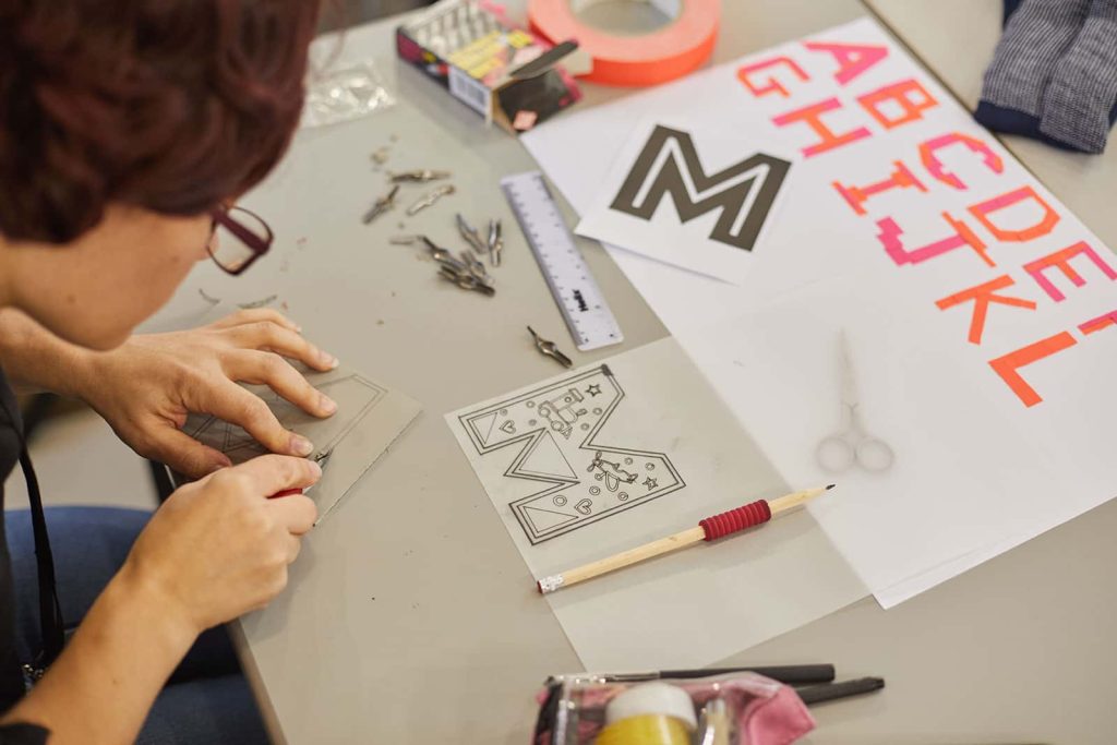 Year 0 student working at Norwich University of the Arts on letter cutting