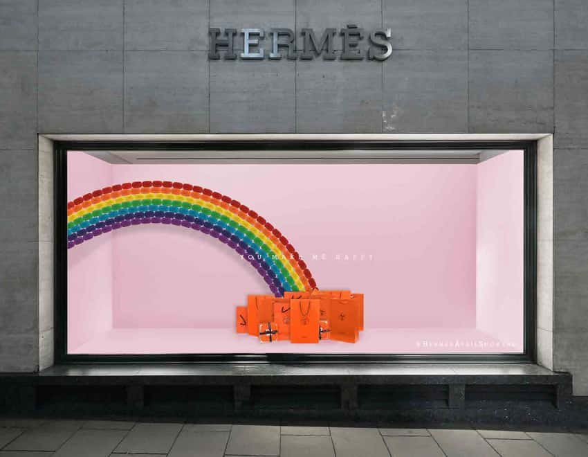 Store window visual merchandising for Hermes, featuring a pink backdrop with a rainbow. At the bottom of the rainbow are Hermes bags. By BA Fashion Communication and Promotion student Beth Poulter