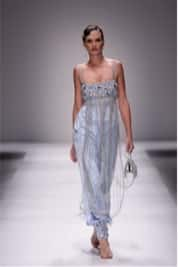 Person walking down catwalk in silver mesh dress