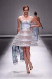 Person walking down catwalk in silver mesh dress