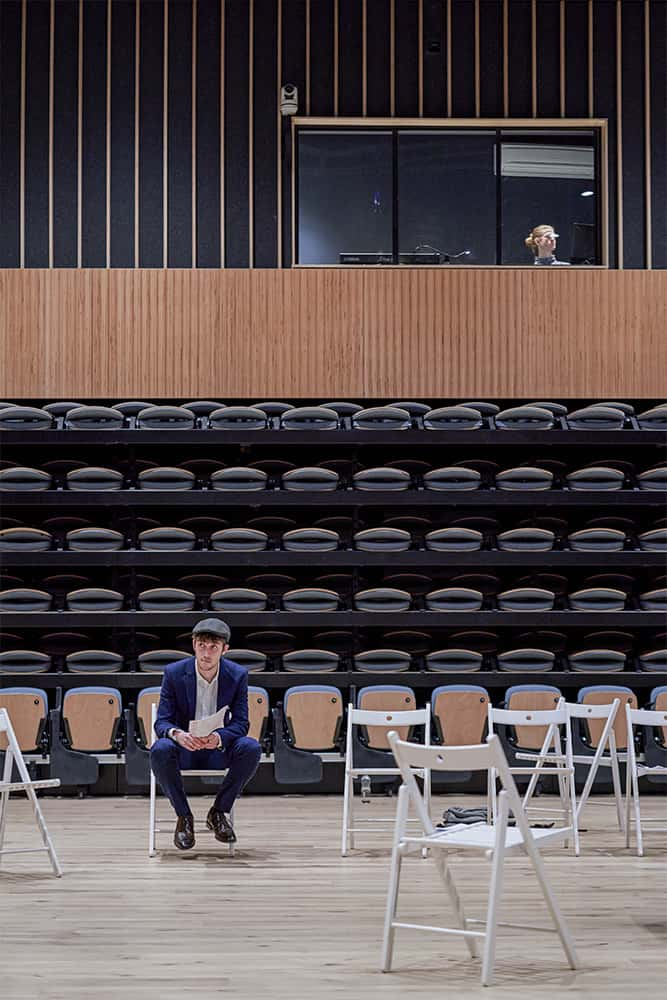 Acting student siting on a white chair in a teaching space in our Duke Street Riverside building.