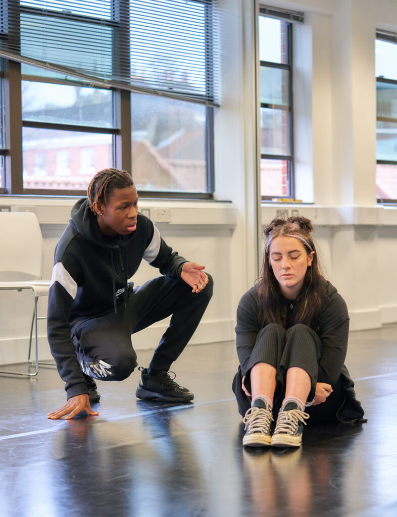 Acting studio. Two students both sitting on the floor