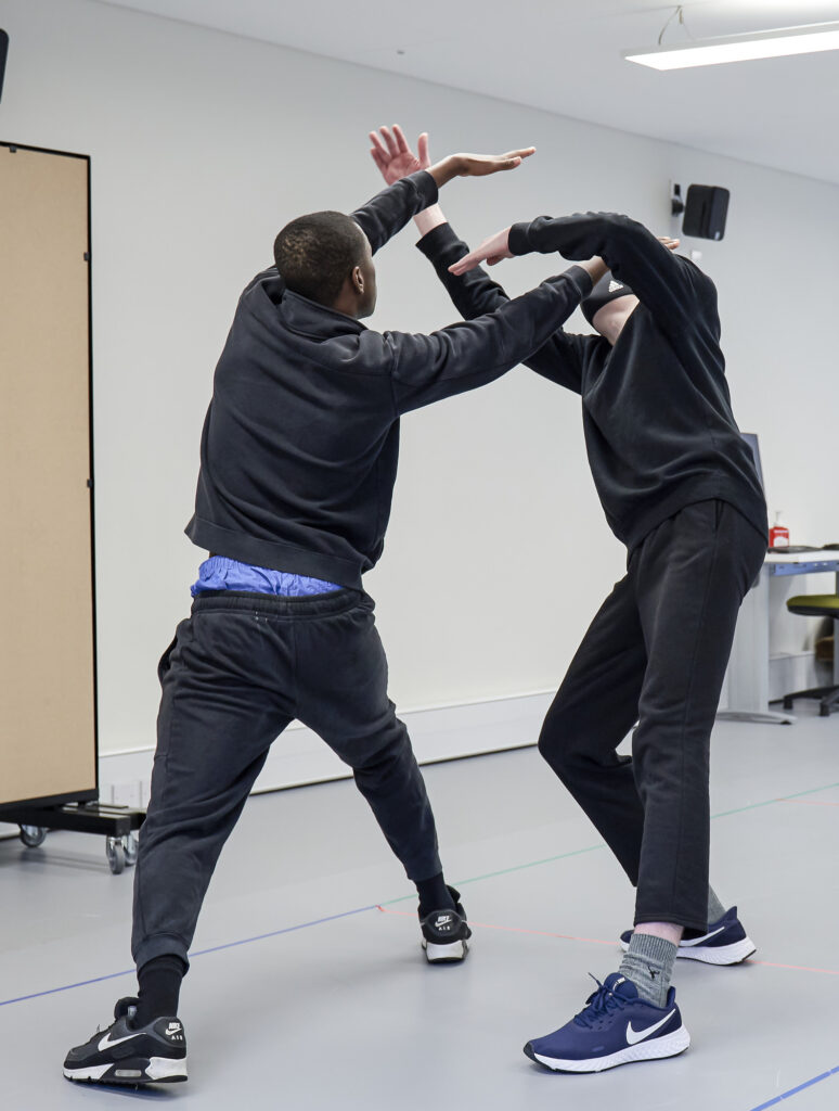 Acting studio two students with arms in air