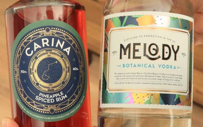 A close up photograph of a bottle of Carina golden pineapple spiced rum on the left, and Melody clear botanical vodka on the right