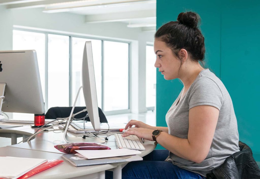 A student using an iMac in the Digital Design Workshop at Norwich University of the Arts