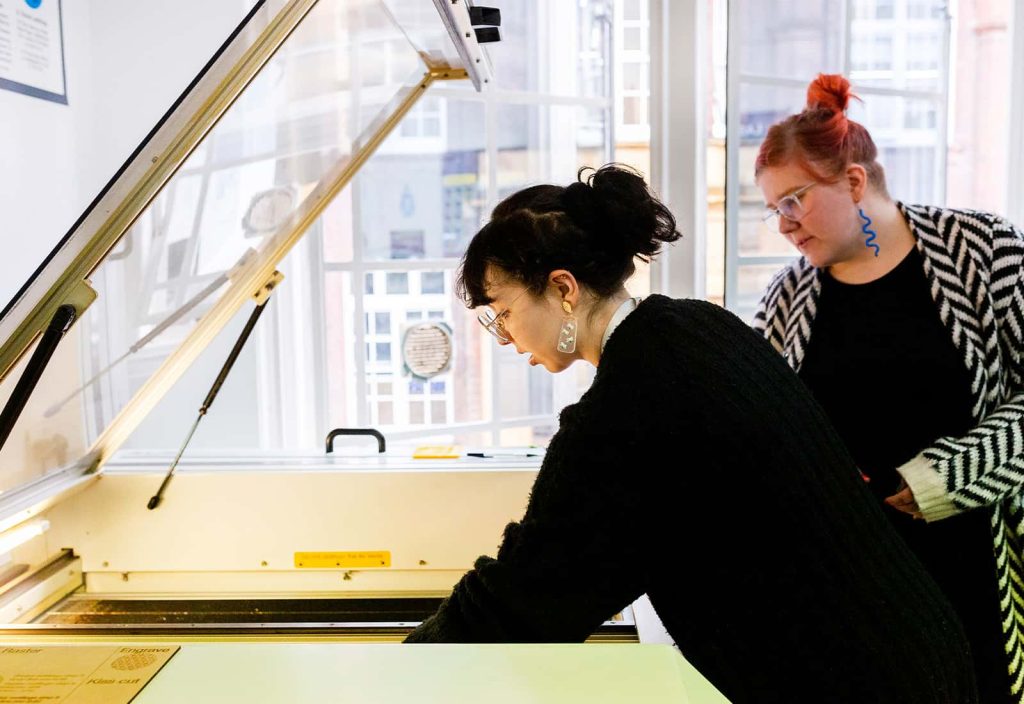 A student lines up their materials for laser cutting in the digital studio