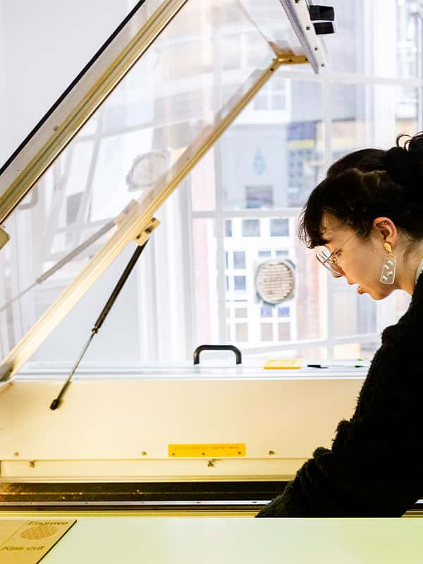 A student lines up their materials for laser cutting in the digital studio