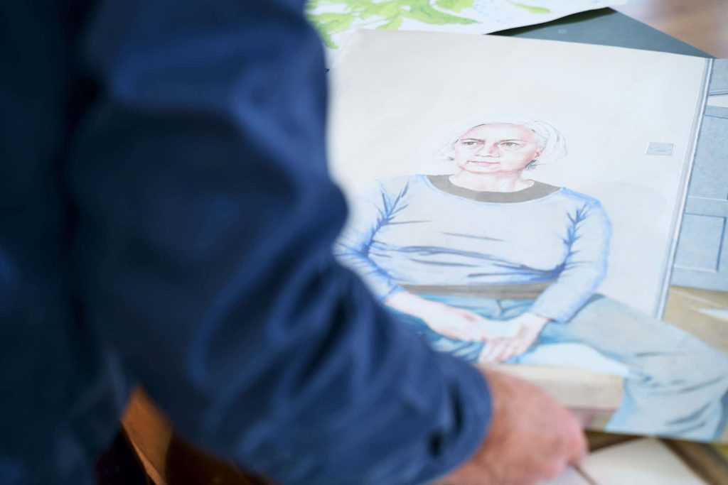 A man in a blue shirt, Will Jefferies looking at his own painting of a woman