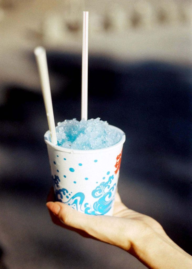 A picture of a person holding blue kakigoori, a Japanese shaved ice desert