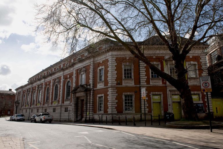 A Georgian building in Norwich that used to be 'Open', on Bank Plain with trees outside it.