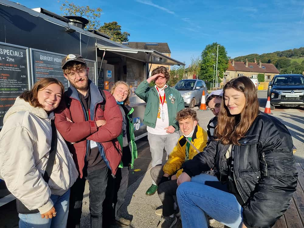 Image showing group of people outside next to a food takeaway van.