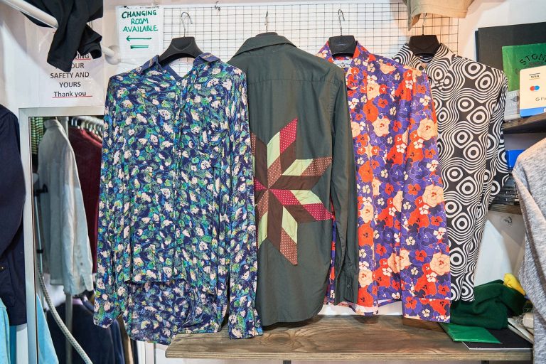 four different shirts in different colours hanging up in a charity shop in Norwich