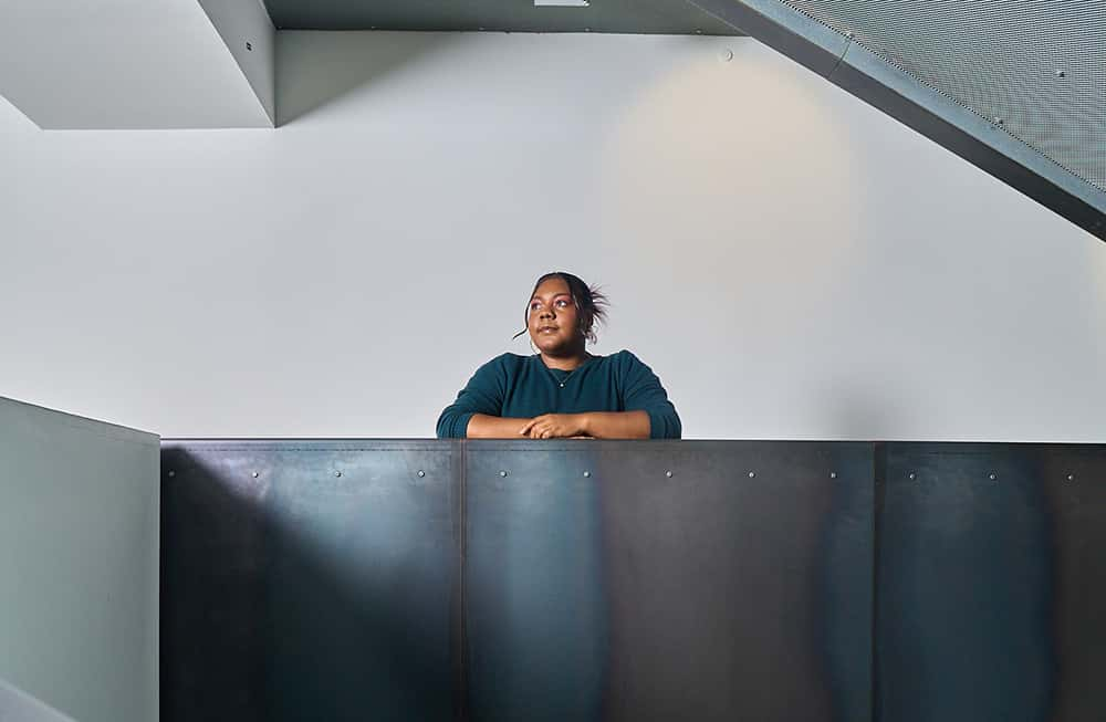 Image showing person leaning on grey staircase wearing a dark green dress