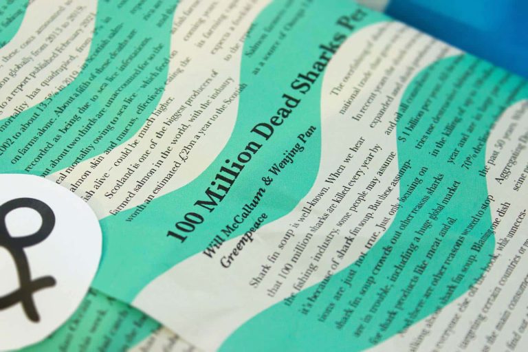 Close-up photo of newspaper packaging for a sustainable no fish and chips brand nchips, by Reiss Tozer, Iona Mound and Ben Mountford. The newspaper contains articles raising awareness of overfishing, and is used to wrap vegan fish and chips in.