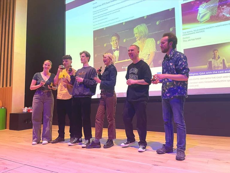 Image showing 6 people on stage in front of a projector holding trophies