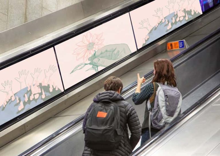 A photograph of two people on an escalator on the London Underground. Alongside the escalator are three panels of illustrations from Ambitious Cities by BA Illustration student Olivia Heseltine. The illustrations show the earth with tall skyscrapers and hands reaching up, anda hand holding a flower, all in a pale pink and green tone