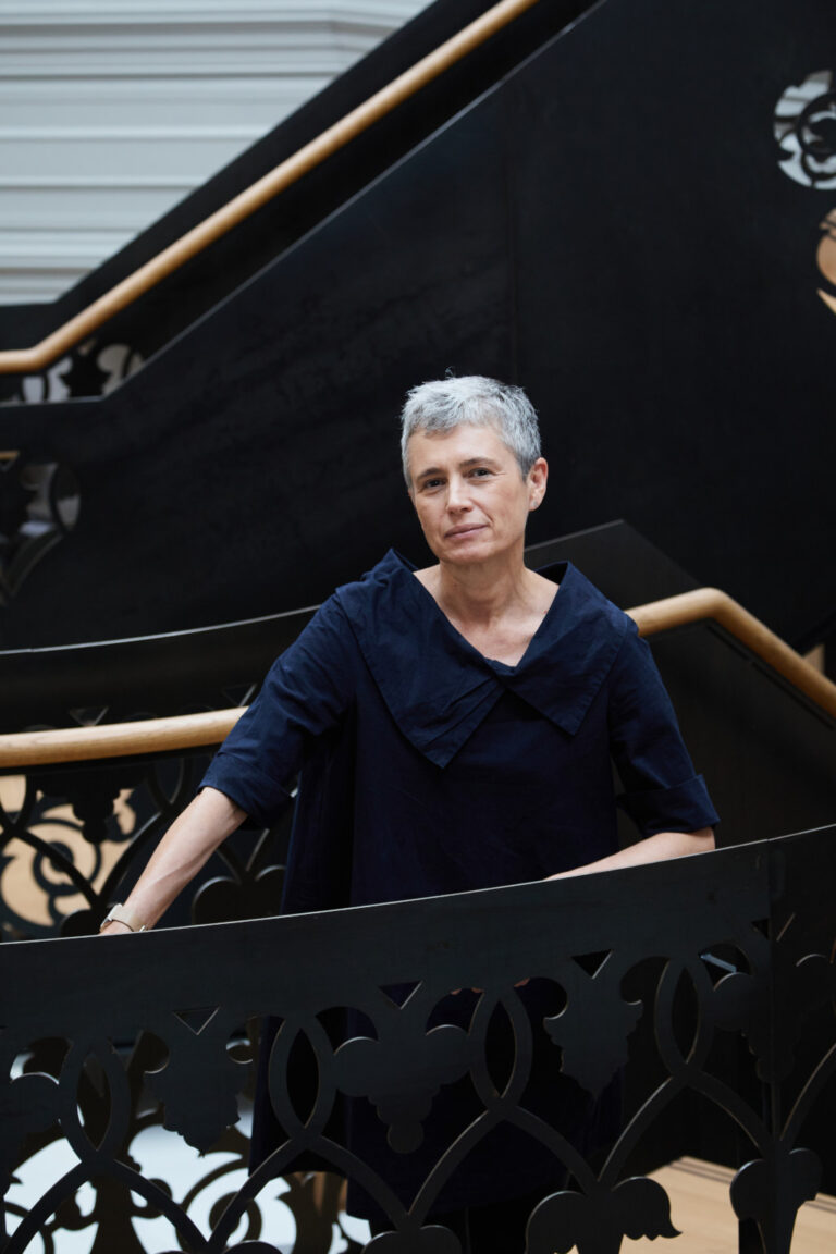 Teresa Stoppani leans against the handrail of the Boardman House building at Norwich University of the Arts which houses the Architecture and Interior Design courses