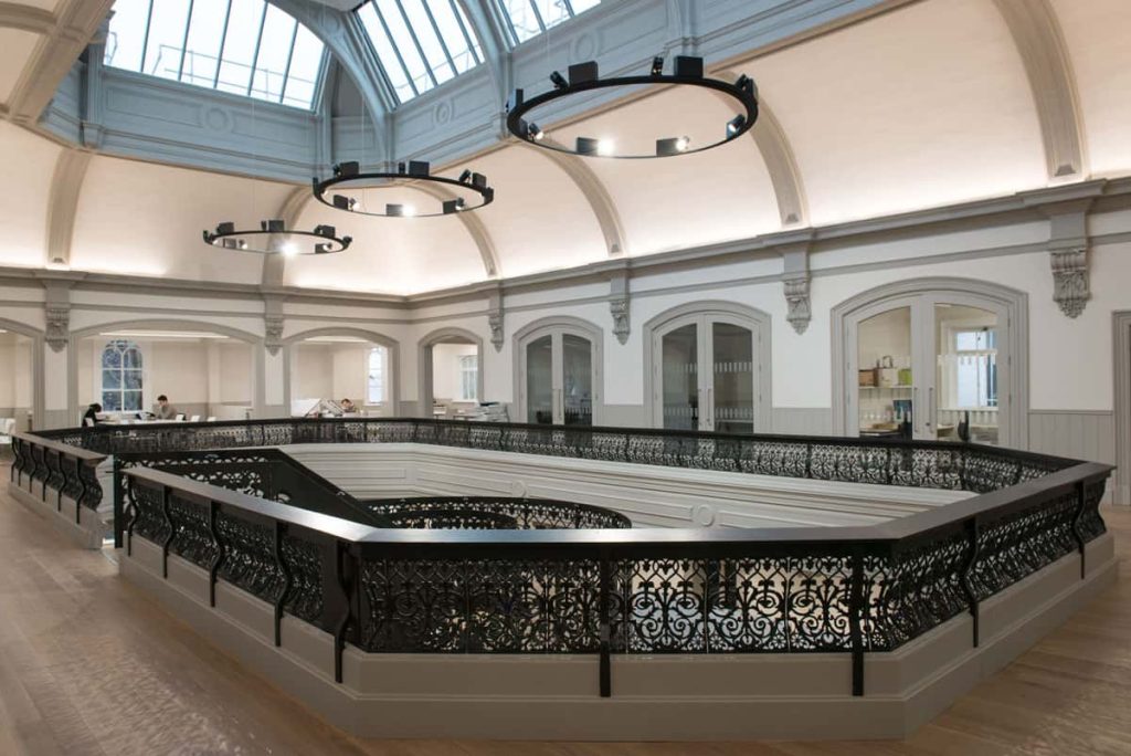 The interior of Boardman House, Norwich showing a staircase and large hanging lights and skylights