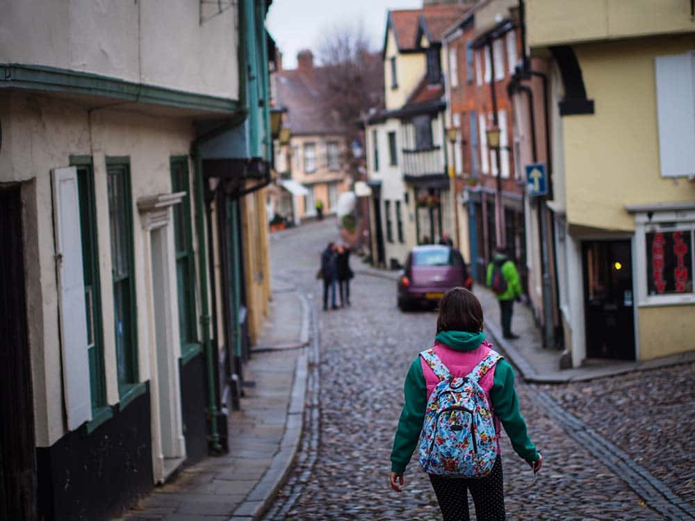 Image showing person with backpack walking down cobbled hill