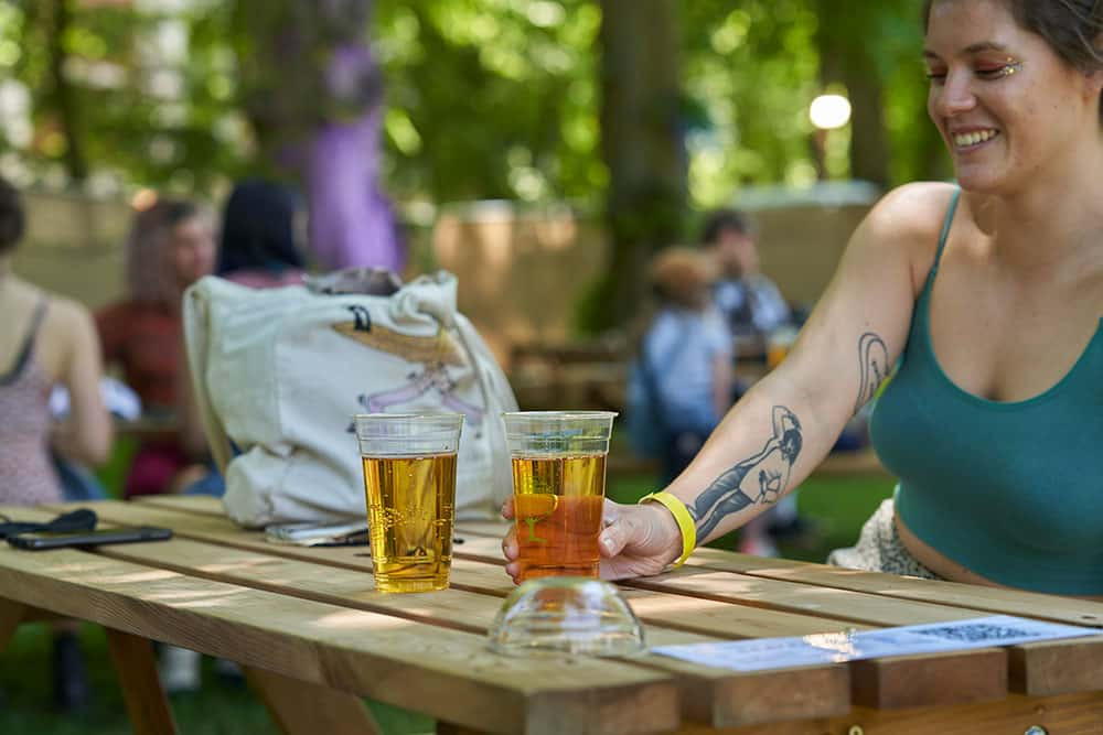 Image showing person sitting outside on picking table drinking beer