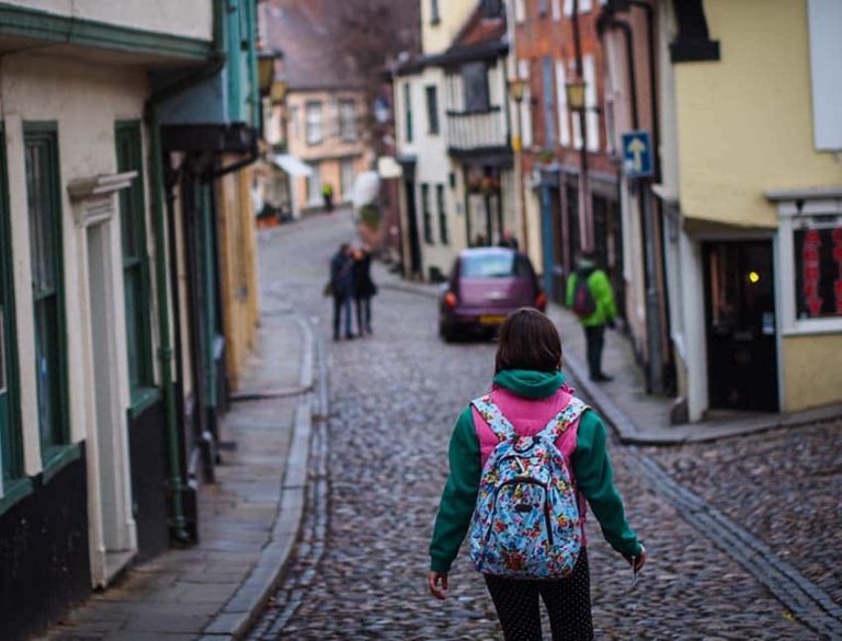 Image showing person with backpack walking down cobbled hill