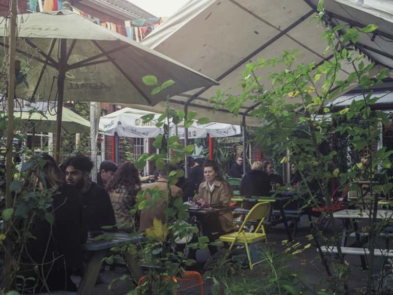 Image of people sitting at The Playhouse outside bar on picnic tables