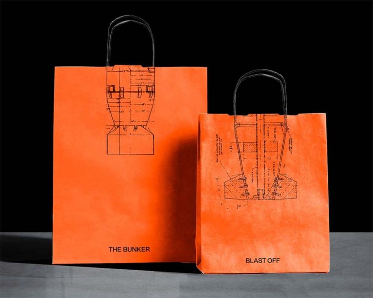 Mock up of two orange shopping bags with missile technical drawings on them